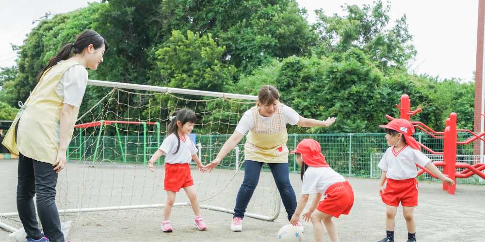 enfants faisant du football en uniforme avec leurs deux professeurs