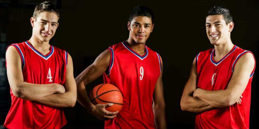 hommes portant des tenues de basket et un ballon