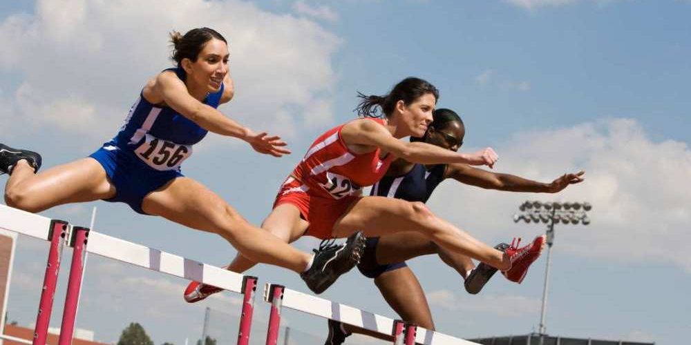 trois femmes participant à une compétition de course de haies